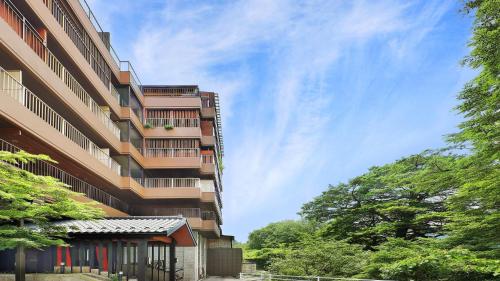 a tall building with trees in front of it at Tsuganoki in Nikko