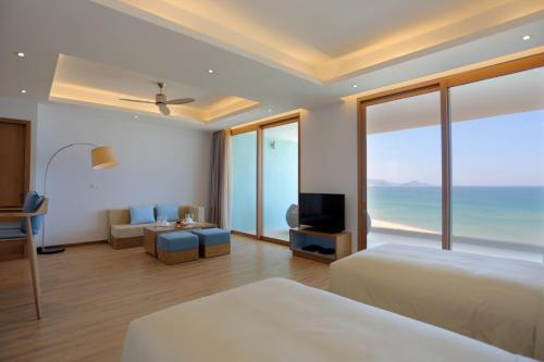 a hotel room with two beds and a view of the ocean at FLC Grand Hotel Quy Nhon in Quy Nhon