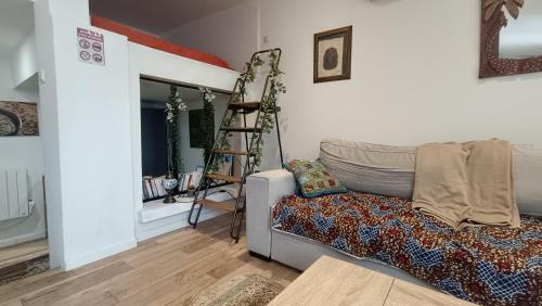 Petit Chalet في سانت كونتان: غرفة معيشة مع أريكة وسلم