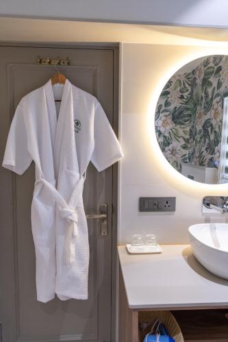 a white robe hanging on a door in a bathroom at Girisadan Boutique Stay in Jaipur