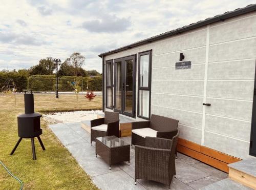 a tiny house with chairs and a grill at Erins Lakes & lodges in Boston