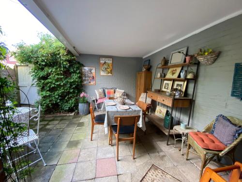 eine Terrasse mit einem Tisch und Stühlen in einem Zimmer in der Unterkunft Quince Cottage in Saint Michaels