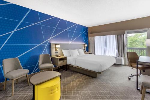 a hotel room with a bed and a blue wall at Comfort Inn Blythewood - North Columbia in Blythewood