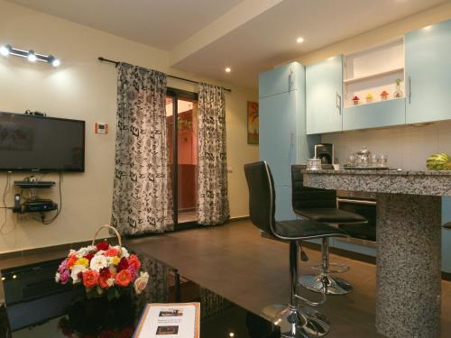 une cuisine et un salon avec un comptoir et des chaises dans l'établissement Ghita Appartement, à Marrakech
