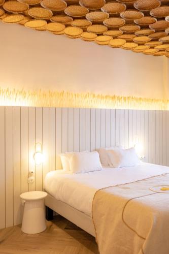 a bedroom with a large bed and a table and lights at Hotel M Soleil - Montpellier Centre Saint Roch in Montpellier