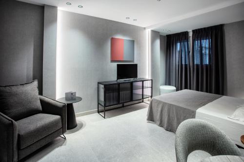 a hotel room with a bed and a chair at Hotel Gran Via in Zaragoza