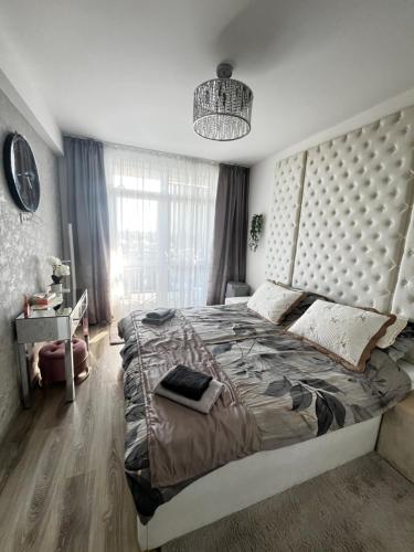 a bedroom with a large bed with a large headboard at Violet Superior in Nyíregyháza