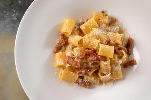 a white plate with a dish of food on it at Rose Garden Palace Roma by OMNIA hotels in Rome