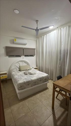 a bedroom with a bed and a table and a ceiling at Panoramic Paradise 5 min to downtown and beach in Zihuatanejo