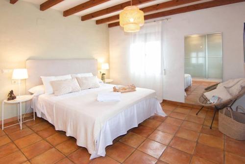 a bedroom with a large white bed in a room at Finca Les Oliveres in Benissa