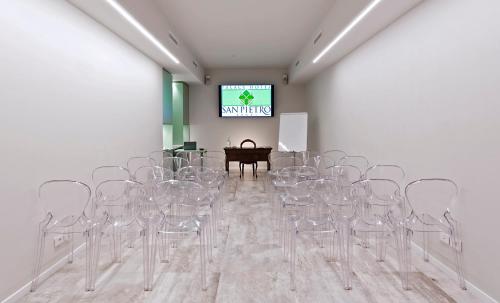 a room with a bunch of empty chairs and a screen at Palace Hotel San Pietro in Bardolino