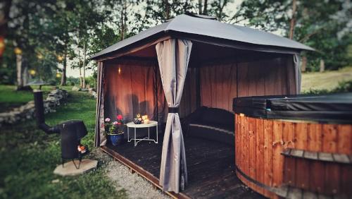 a wooden gazebo with a table in it at Orrefors Vandrarhem in Nybro