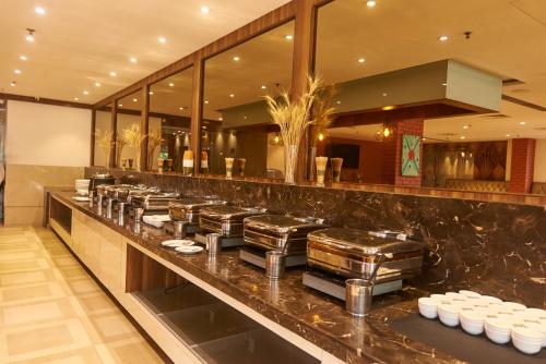 a restaurant counter with a row of stools at Tania President Inn in Shirdi