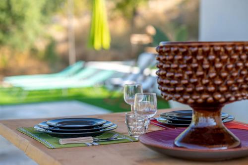 a table with plates and glasses and a basket on it at Collemeti - Country House in Noto