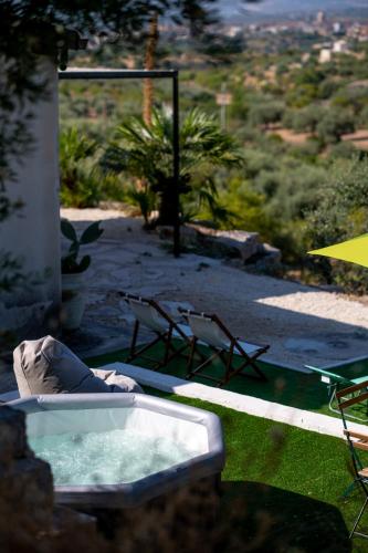 a hot tub sitting on top of a yard at Collemeti - Country House in Noto