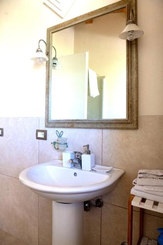 a bathroom with a white sink and a mirror at Collemeti - Country House in Noto
