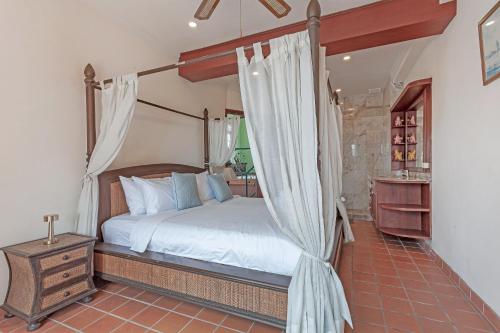 ein Schlafzimmer mit einem Himmelbett mit weißen Vorhängen in der Unterkunft Villa Italia in Ban Nong Chaeng