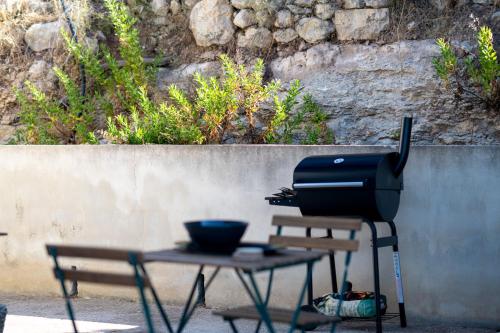 a grill sitting on a table next to a bench at Collemeti - Country House in Noto