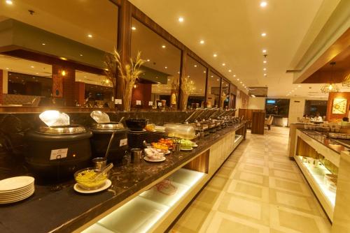 a restaurant with a counter with dishes on it at Tania President Inn in Shirdi