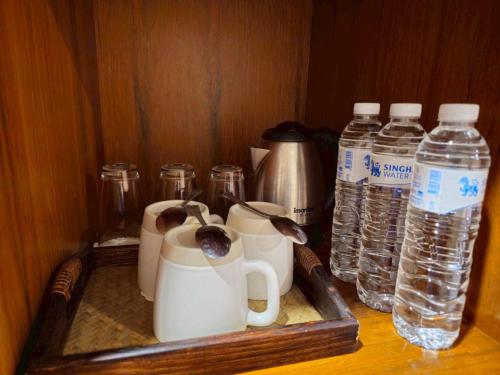 a tray with cups and bottles of water in a drawer at Baan Lanna ChiangRai in Chiang Rai