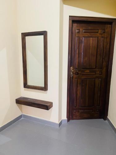 a wooden door with a mirror next to it at Trinco Ashvi Family Guest in Trincomalee