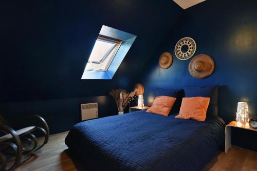 a blue bedroom with a bed and a window at Maison du Bonheur - Parking - Wifi in Vains