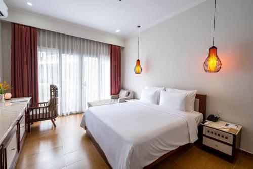 a bedroom with a large white bed and a chair at Minera Hot Springs Binh Chau in Binh Chau