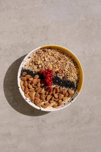 a bowl of food with nuts and berries on a table at Curolla Petit Hotel in Maria de la Salut