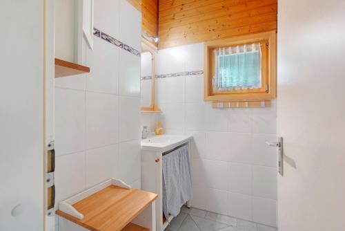 a white bathroom with a sink and a window at Haus 7 Bernau in Bernau im Schwarzwald