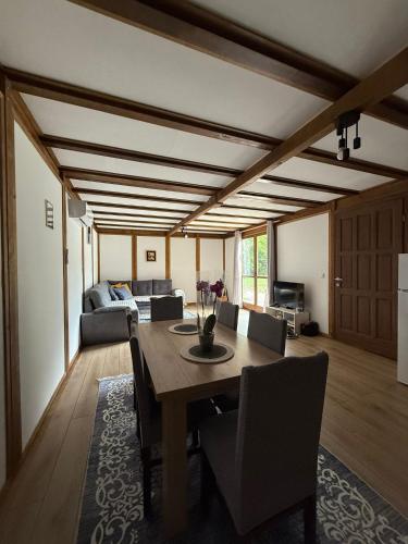 a dining room with a table and a couch at Vikendica Čardak in Srebrenik