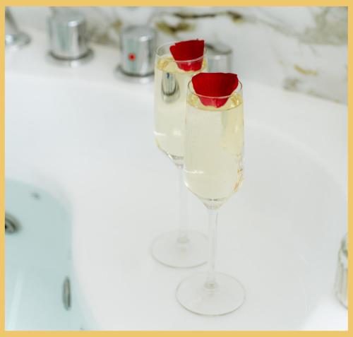two glasses of champagne on a white counter at B Unique Appartement Jacuzzi I Cinéma in Gaillard