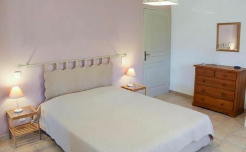 a bedroom with a large white bed and a dresser at Le Petit Etang in Gréoux-les-Bains