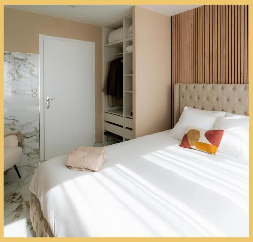 a bedroom with a large white bed with two pillows at B Unique Appartement Jacuzzi I Cinéma in Gaillard