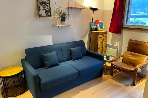 un salon avec un canapé bleu et une chaise dans l'établissement Modern Apt With View On The Aiguille Du Midi, à Chamonix-Mont-Blanc