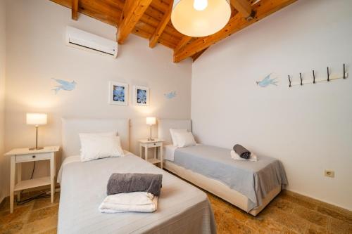 two beds in a room with wooden ceilings at Villa Anemos in Gaios