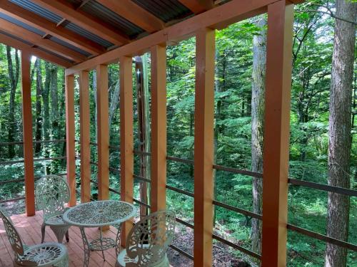 a screened in porch with a table and chairs at Kitakaruizawa Morino Bessou NO1 in Kita-karuizawa