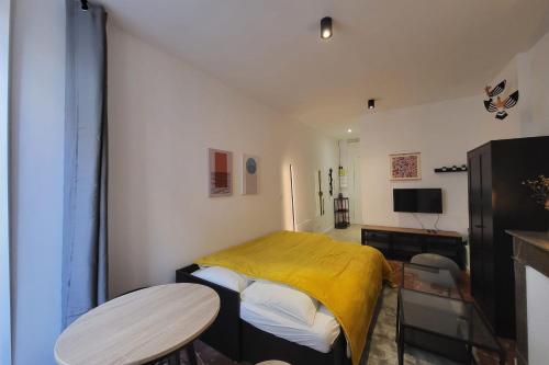 une chambre avec un lit avec une couverture jaune dans l'établissement Nice and bright studio in the center of Toulouse, à Toulouse