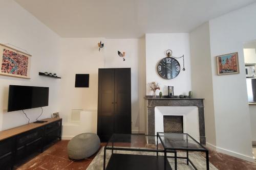 - un salon avec une cheminée et une horloge murale dans l'établissement Nice and bright studio in the center of Toulouse, à Toulouse