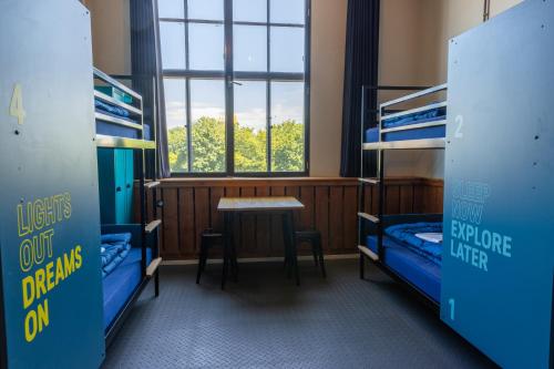 a dorm room with bunk beds and a table at Stayokay Hostel Eindhoven in Eindhoven