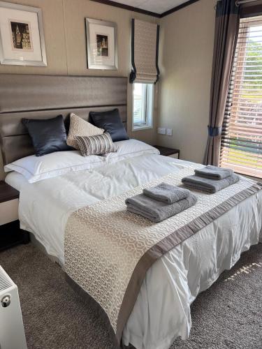 a bedroom with a large bed with towels on it at Drift Lodge in Tain