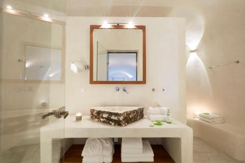 ein Badezimmer mit Waschbecken, Spiegel und Badewanne in der Unterkunft Villa Aura in Firostefani