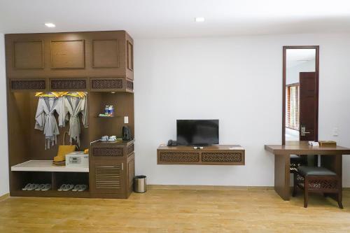a room with a closet and a desk and a tv at Minera Hot Springs Binh Chau in Binh Chau