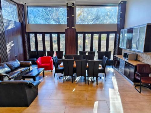 a dining room with a table and chairs and windows at Monte Christo Hotel in Bloemfontein