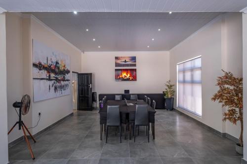 a dining room with a table and chairs and a fireplace at Jetsetters in Port Elizabeth
