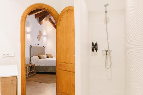 a bathroom with a shower and a door to a bedroom at Curolla Petit Hotel in Maria de la Salut