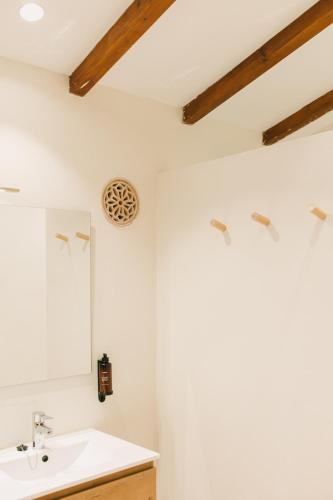 a bathroom with a sink and a mirror at Curolla Petit Hotel in Maria de la Salut
