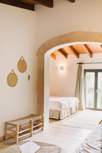 a bedroom with a bed and a large window at Curolla Petit Hotel in Maria de la Salut