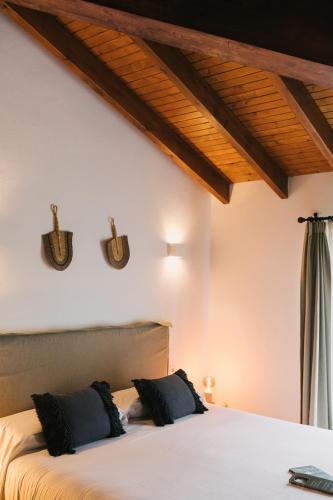a bedroom with a bed with two pillows on it at Curolla Petit Hotel in Maria de la Salut