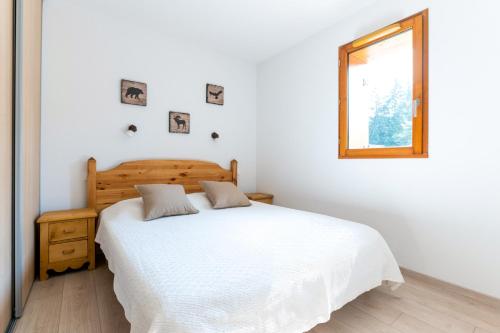 a bedroom with a white bed and a window at Terrasse avec vue sur les montagne pour 6 in La Joue du Loup