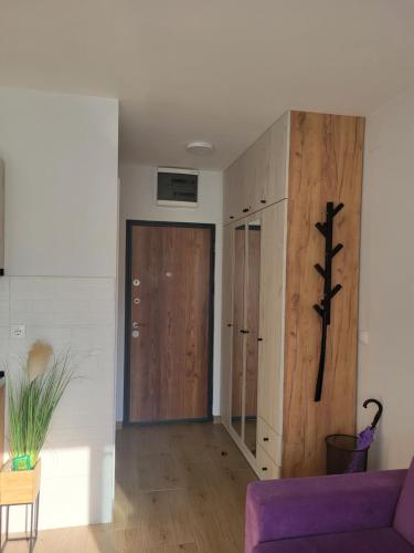un soggiorno con divano viola e porta in legno di Studio Lola Jezero a Divčibare